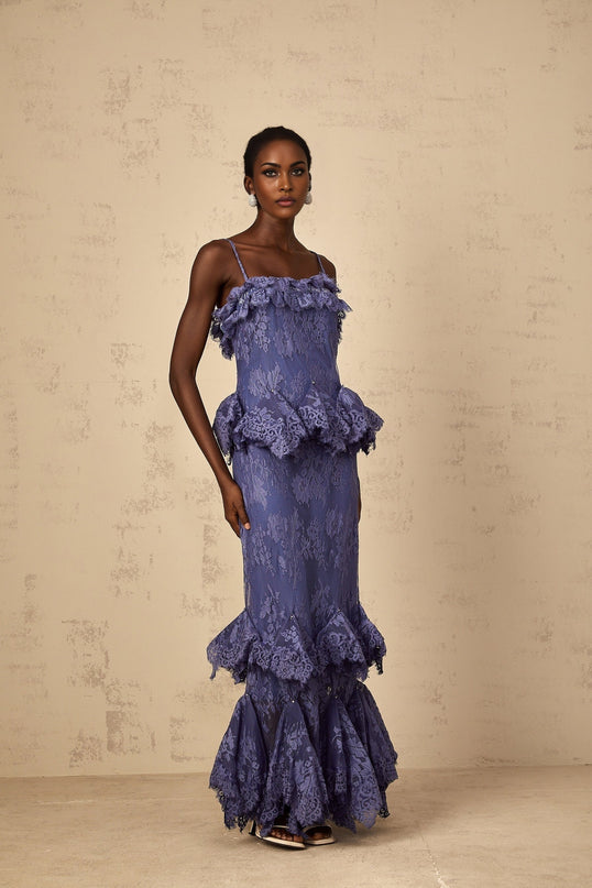 A long purple maxi dress with floral lace pattern and ruffled details featuring a feminine silhouette