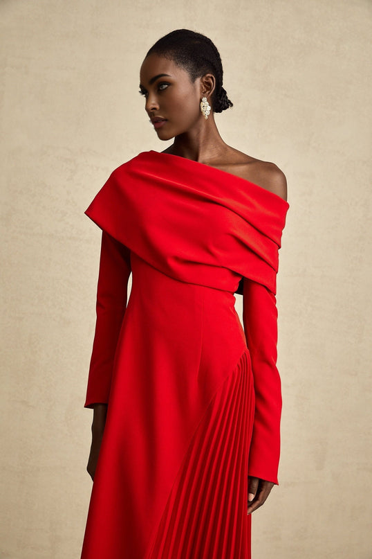 A long red maxi dress with a high slit and pleated skirt perfect for Valentines Day featuring a fitted bodice and flowing design