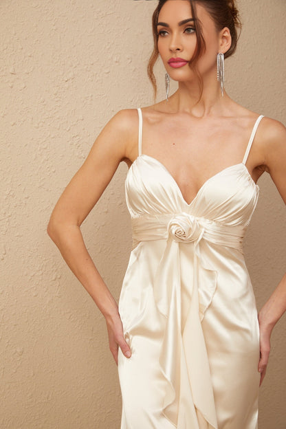 A long satin maxi dress in white with a corset bodice featuring colorful floral applique details and a flowing skirt