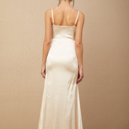 A long satin maxi dress with a corset bodice featuring floral applique details and a flowing skirt in a light color