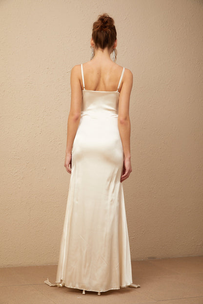 A long satin maxi dress with a corset bodice featuring floral applique details and a flowing skirt in a light color