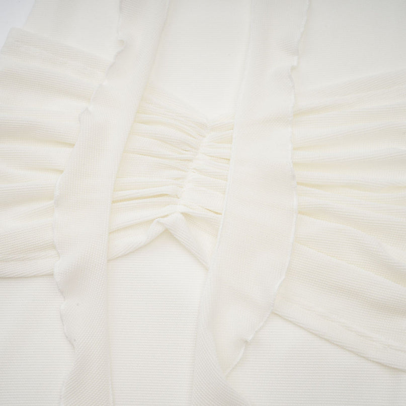 A long white knit maxi dress with glittered floral appliques adorning the fabric named Wanda