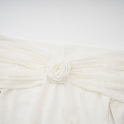 A long white knit maxi dress with glittery floral appliques adorning the fabric named Wanda