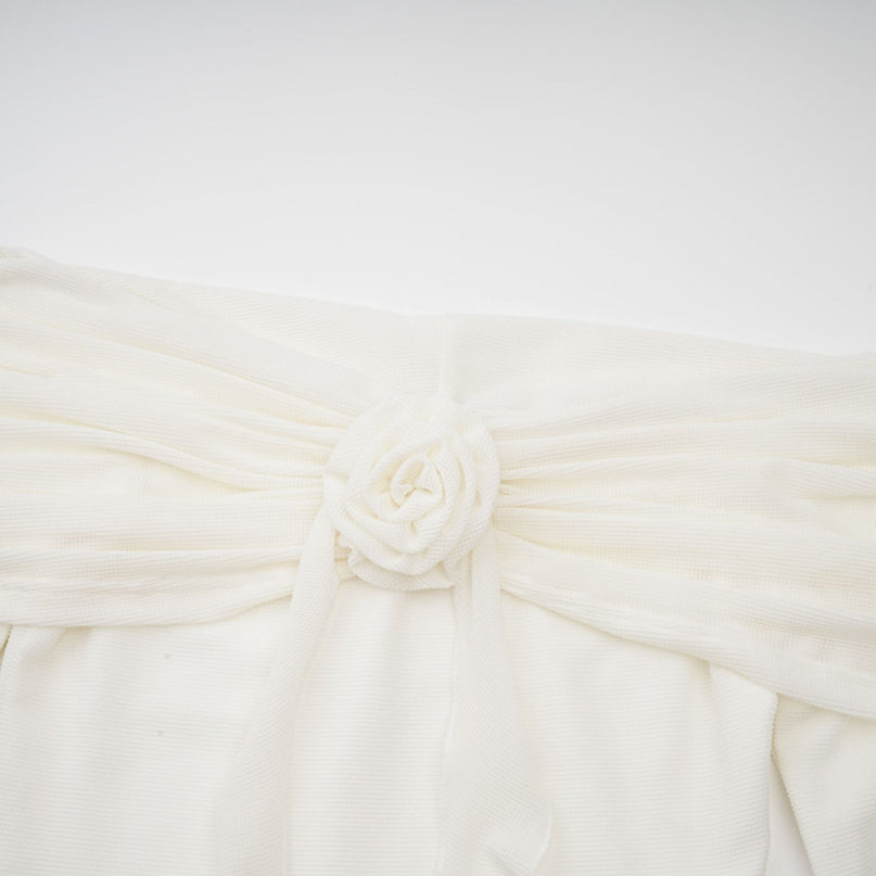 A long white knit maxi dress with glittery floral appliques adorning the fabric named Wanda