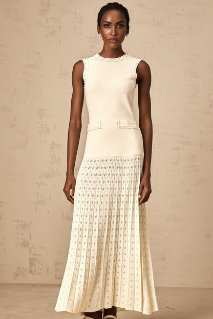 A long white knitted maxi dress with faux pearl embellishments throughout the fabric