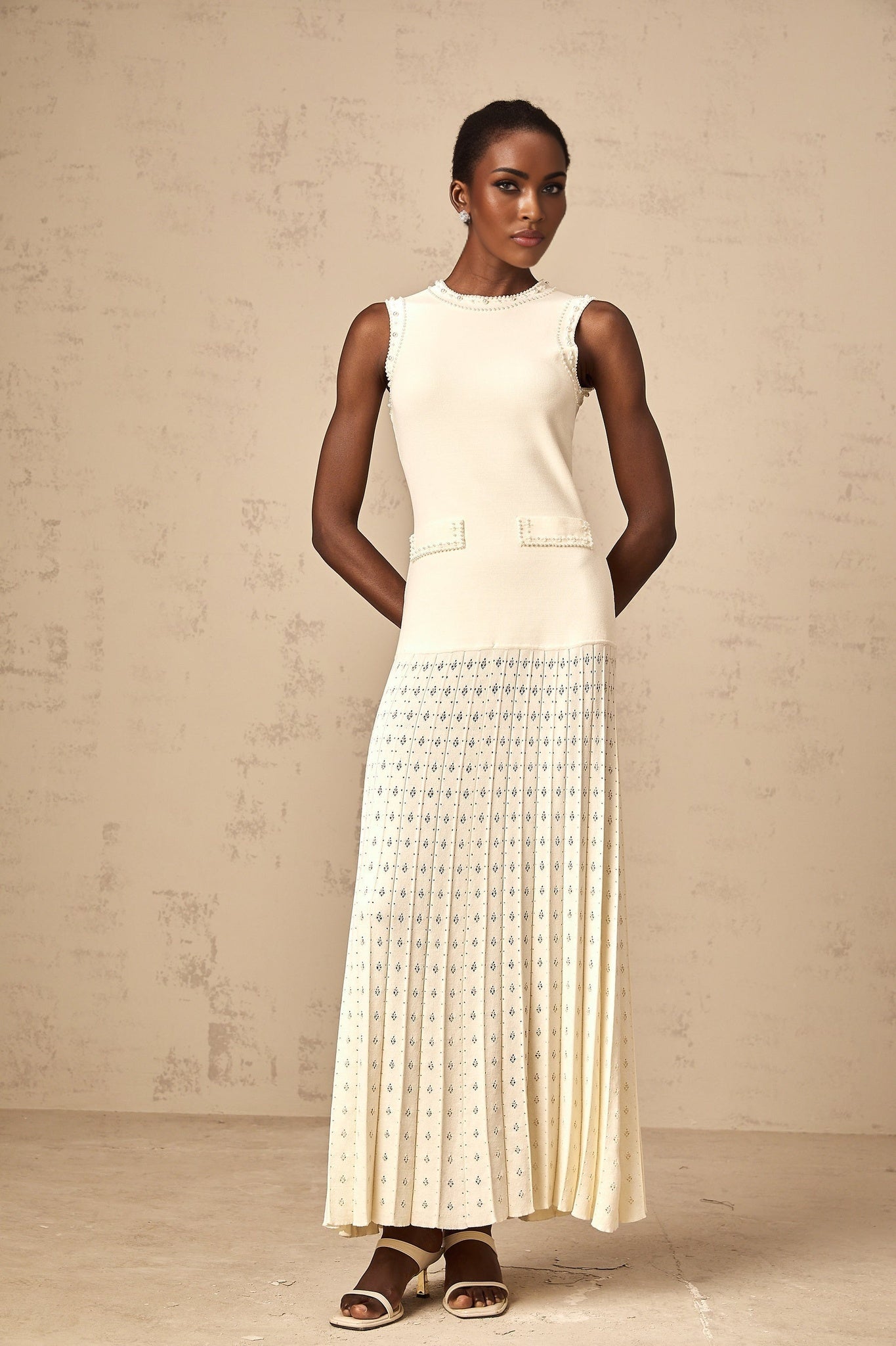 A long white knitted maxi dress with faux pearl embellishments