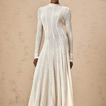 A long white lace maxi dress with a wavy pattern design featuring a flowy silhouette and delicate lace details throughout