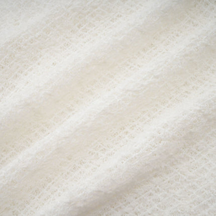 A long white lace maxi dress with a wavy pattern throughout featuring a feminine silhouette and delicate details named Athena