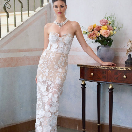 A long white maxi dress with a corset bodice featuring floral appliqué details named Brigitte