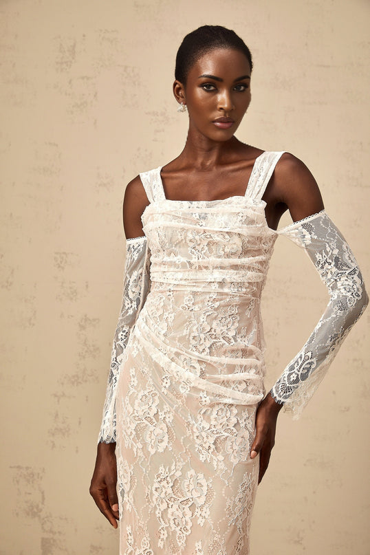 A long white maxi dress with a corset bodice featuring ruched floral lace detailing and a fitted silhouette named Berenice