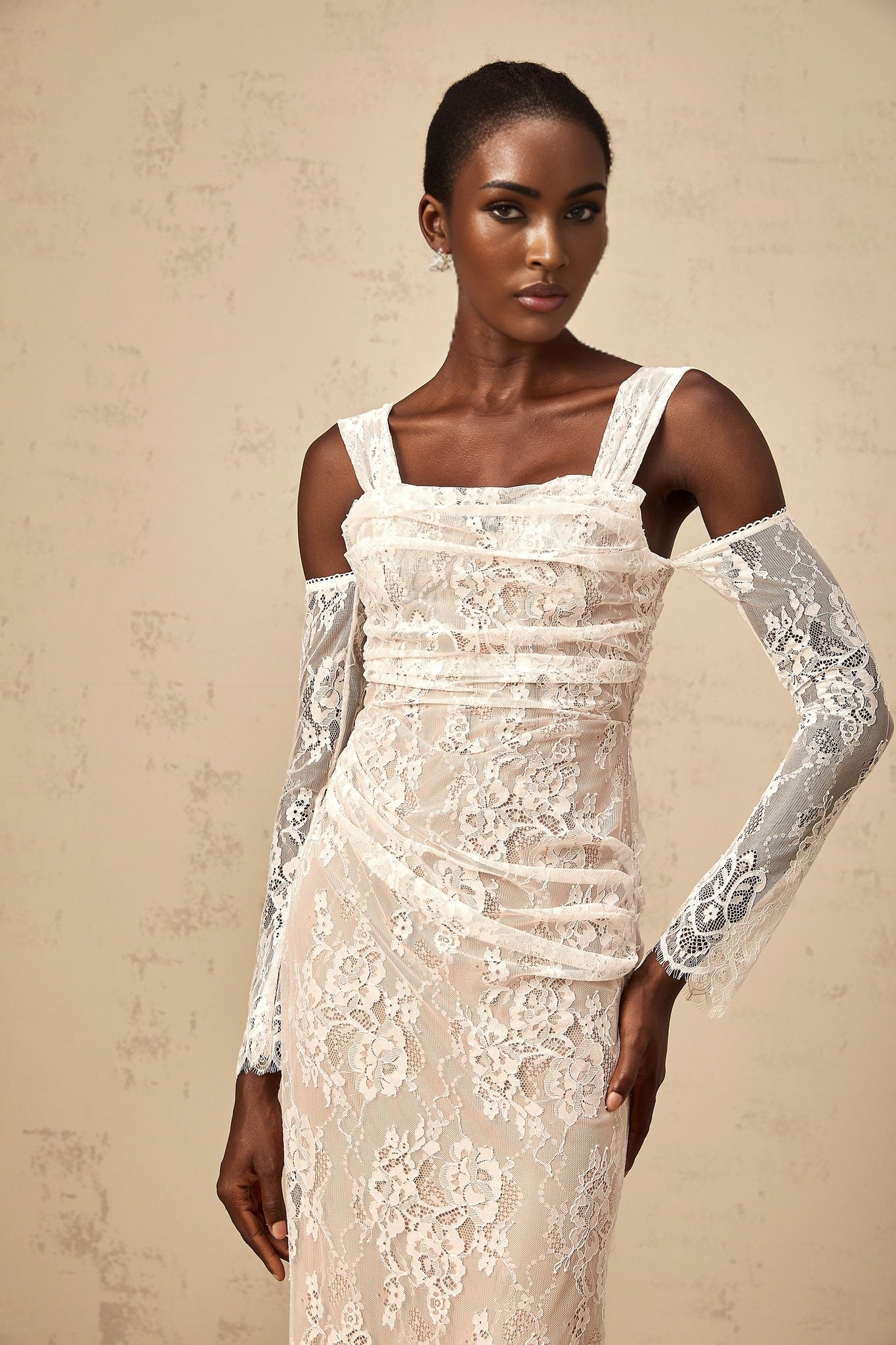 A long white maxi dress with a corset bodice featuring ruched floral lace detailing and a fitted silhouette named Berenice