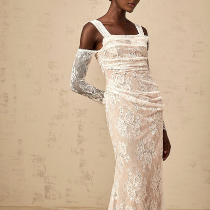 A long white maxi dress with a corset bodice featuring ruched floral lace detailing and a flowing skirt