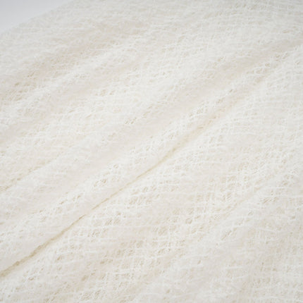 A long white maxi dress with a wavy lace pattern covering the entire garment featuring a feminine and elegant design