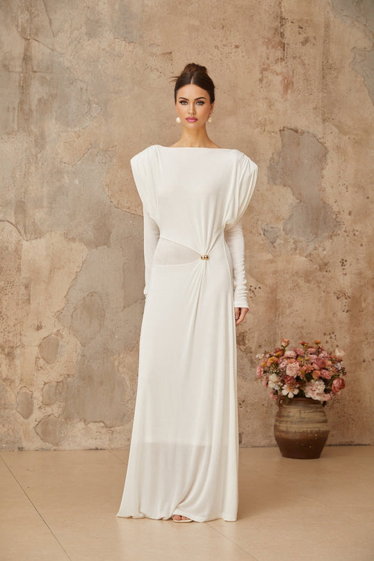 A long white maxi dress with draped and shirred detailing featuring a fitted bodice and flowing skirt