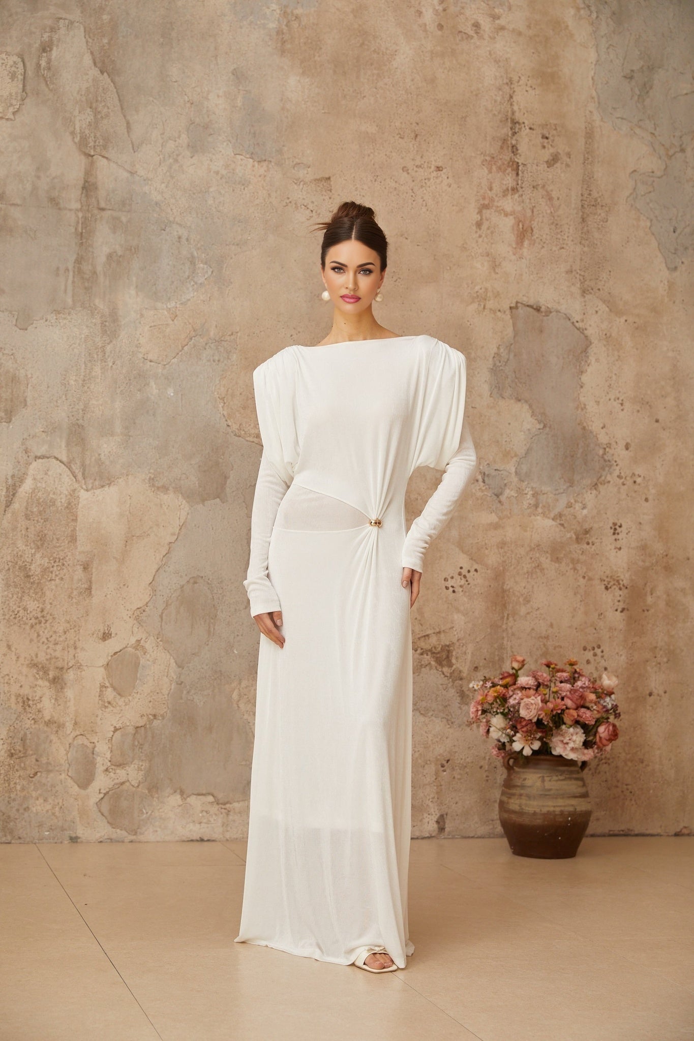 A long white maxi dress with draped and shirred details named Margot featuring a flowing silhouette and elegant design