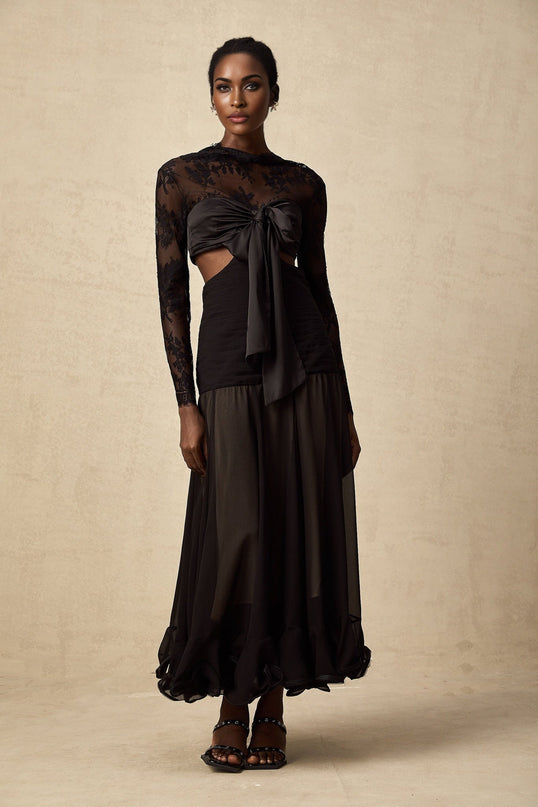 A long white maxi dress with floral lace panels and sheer detailing featuring a fitted bodice and flowing skirt