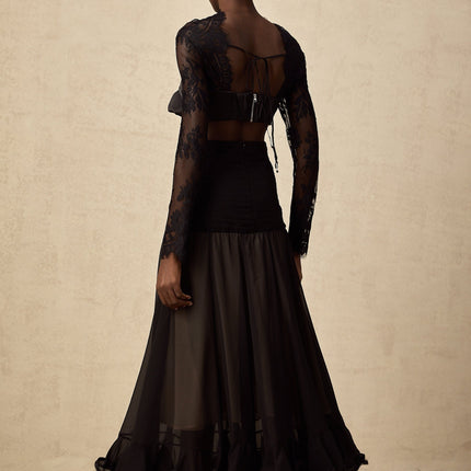 A long white maxi dress with floral lace panels and sheer details featuring a high neckline and long sleeves