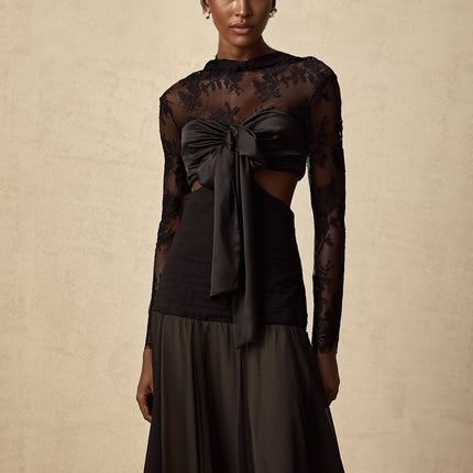 A long white maxi dress with floral lace panels and sheer sections flowing elegantly to the floor