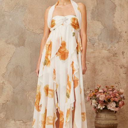 A long white maxi dress with floral print and ruffled tulle details featuring a romantic and ethereal design