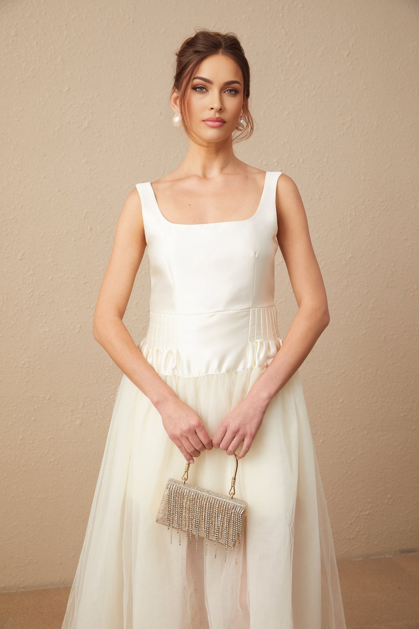 A long white maxi dress with satin and tulle panels featuring a fitted bodice and flowing skirt
