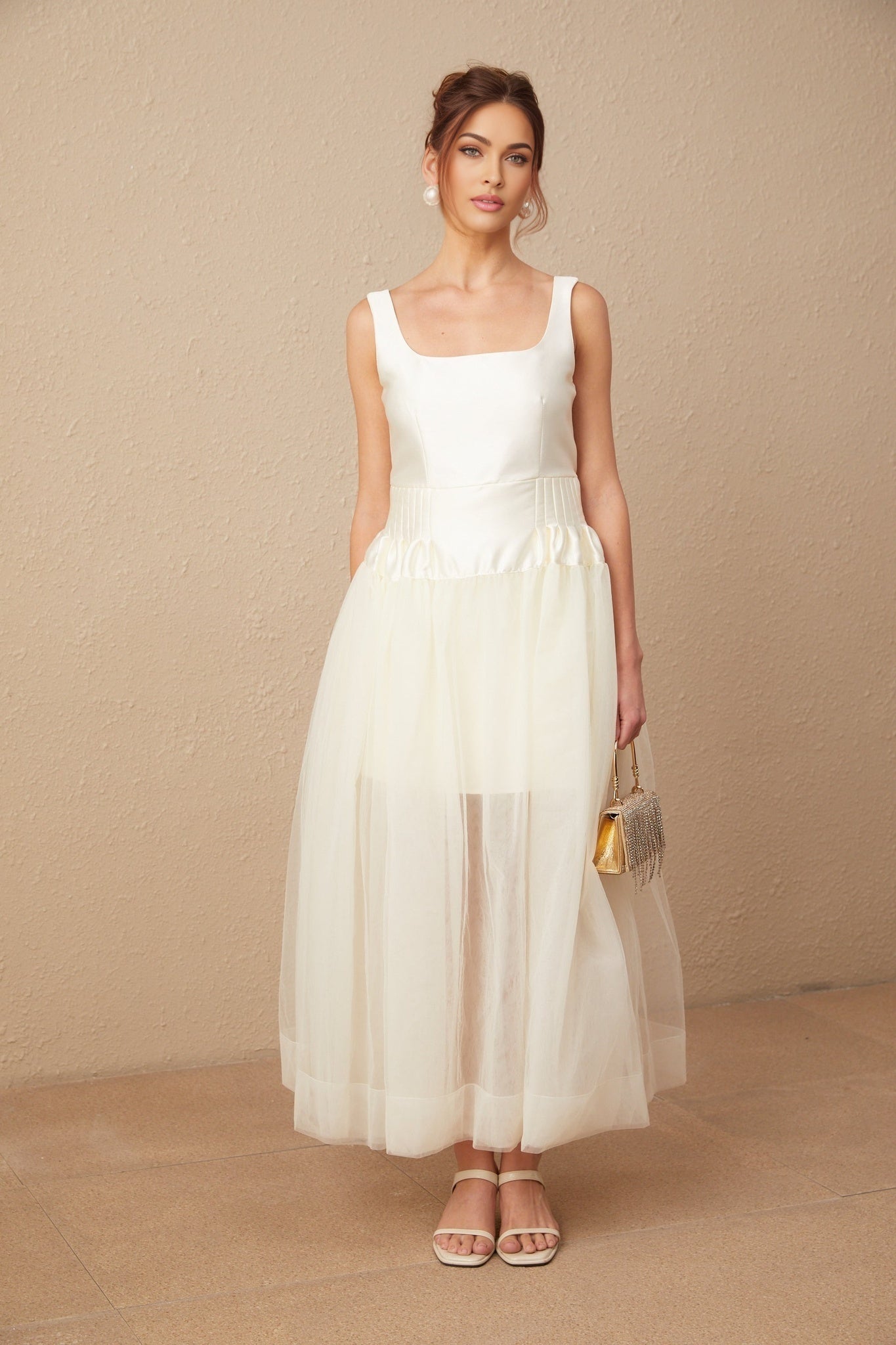 A long white maxi dress with satin and tulle panels featuring a flowy silhouette and delicate details