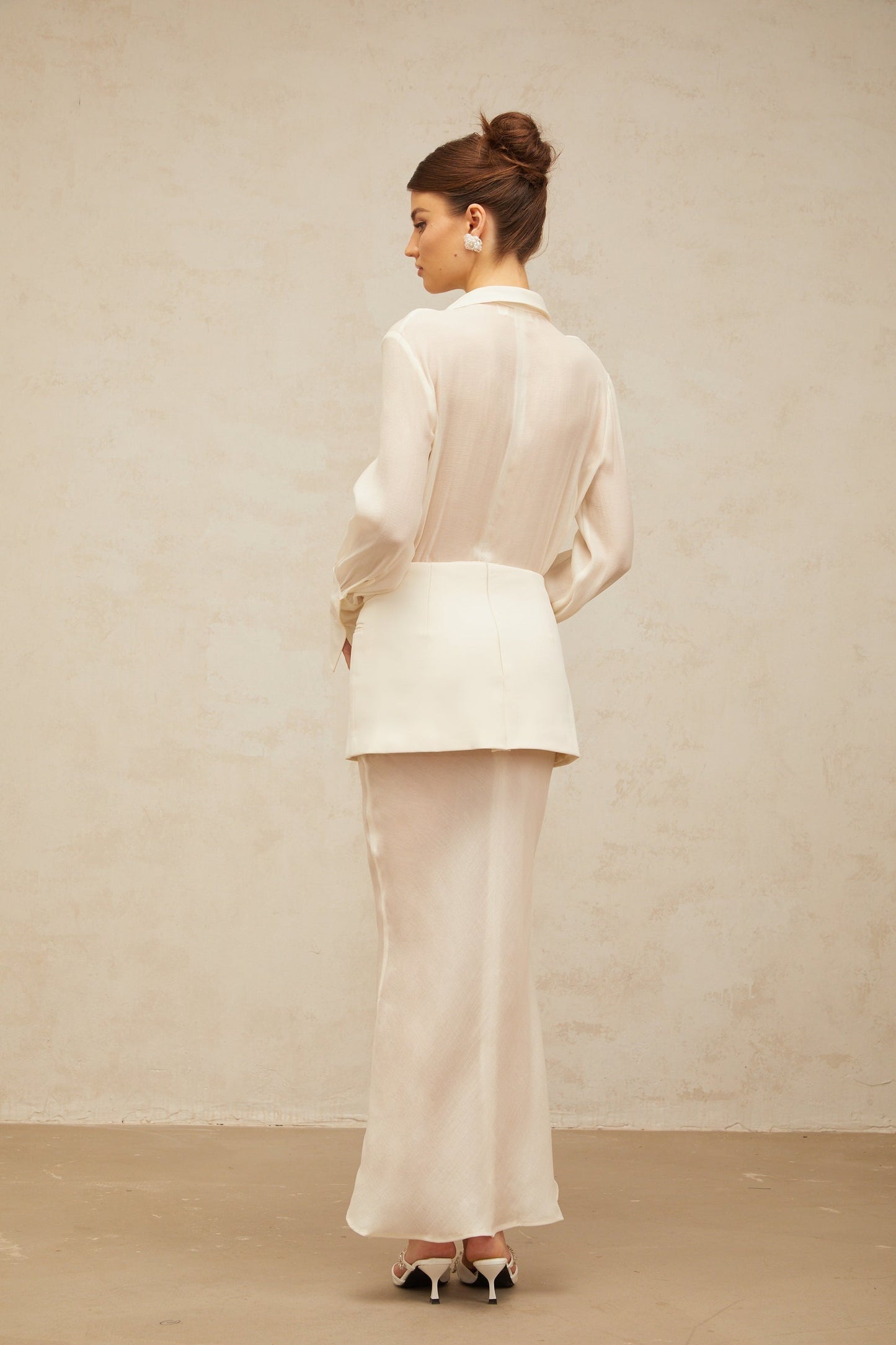 A long white maxi dress with sheer panels and a flowy silhouette