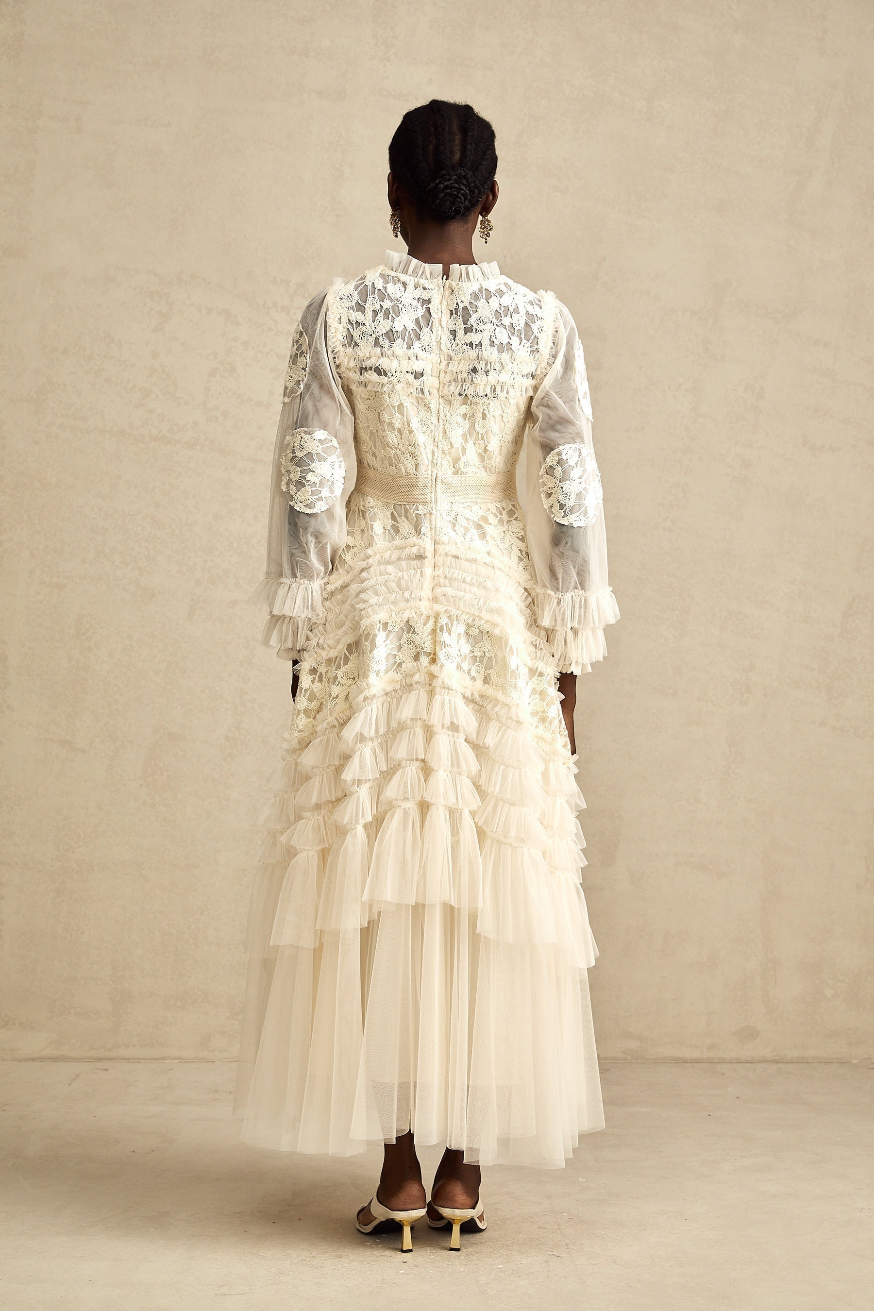 A long white maxi dress with sheer tulle layers and colorful floral embroidery details throughout featuring a flowing silhouette and delicate Capucine design