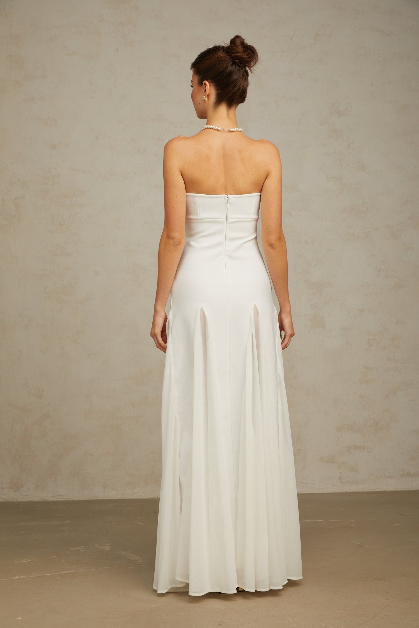 A long white maxi dress with tulle paneling details named Nathalie featuring a flowing silhouette and delicate feminine design