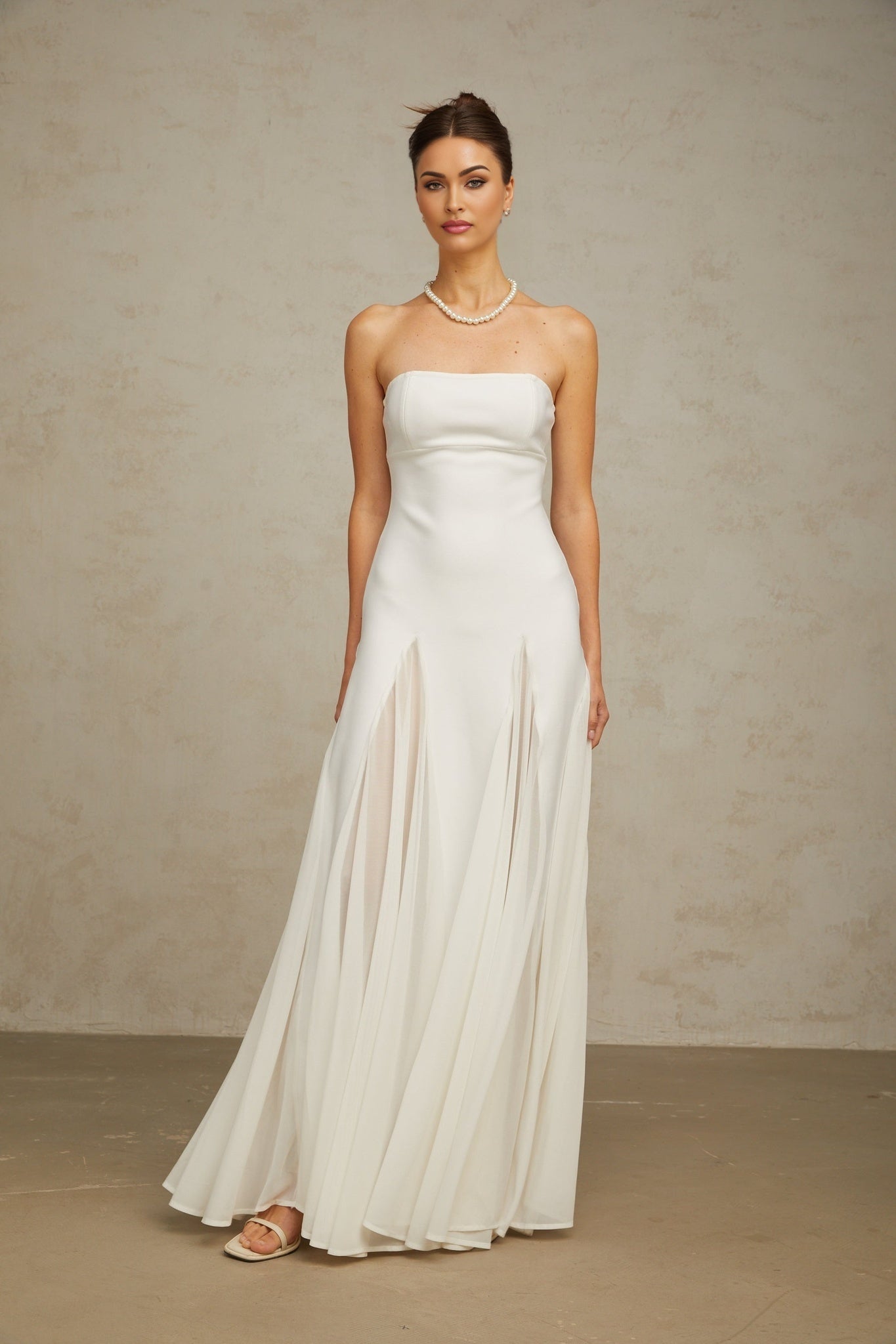 A long white maxi dress with tulle paneling named Nathalie featuring a flowy silhouette and delicate design details