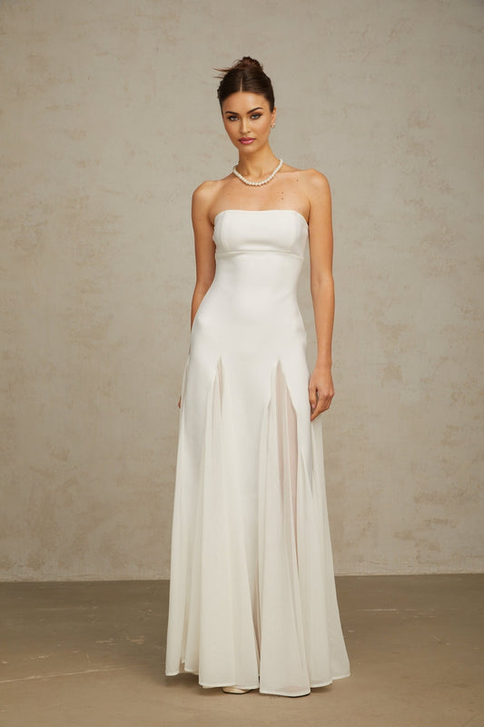 A long white maxi dress with tulle paneling named Nathalie featuring a flowy silhouette and delicate sheer details