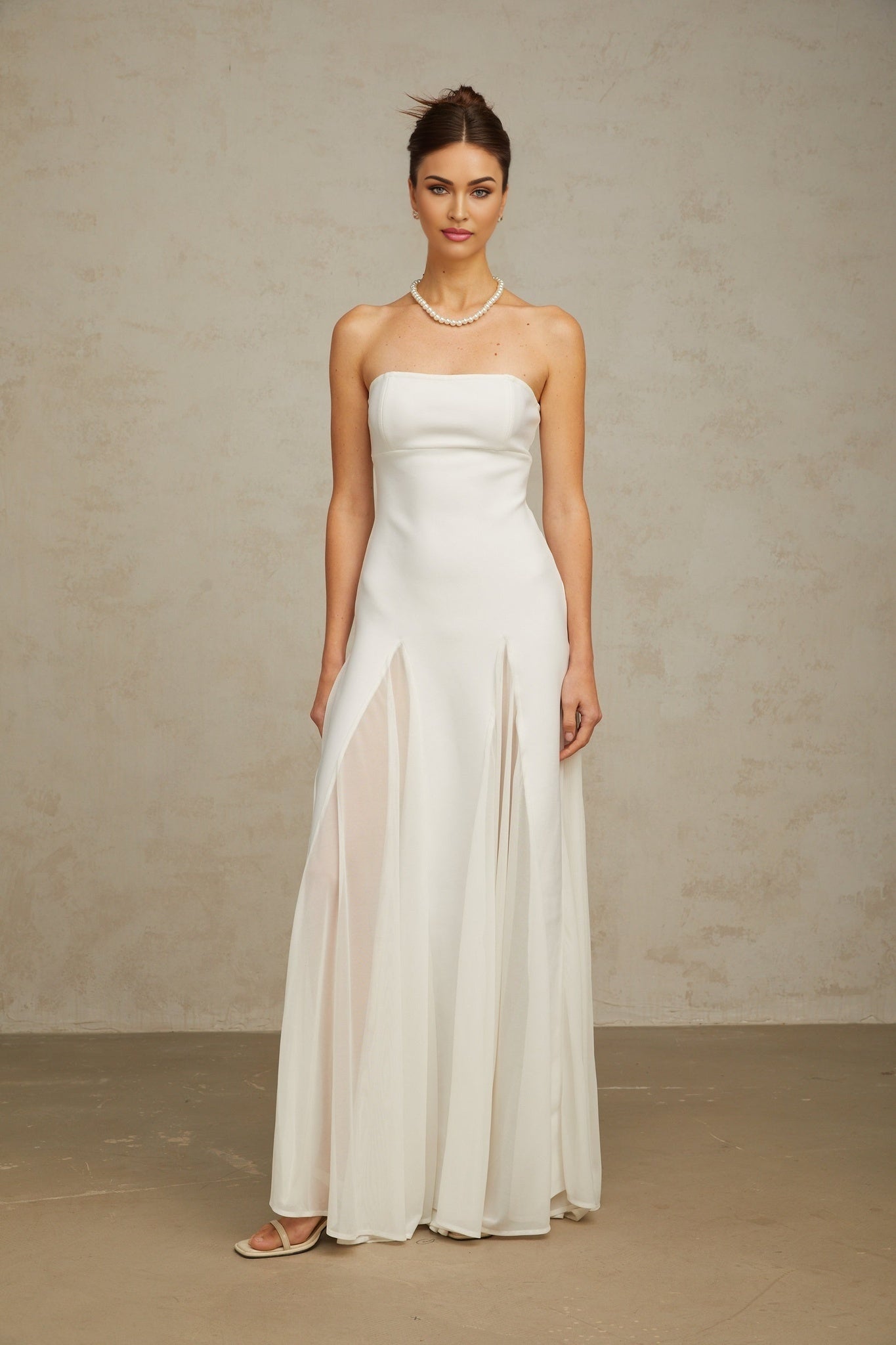 A long white maxi dress with tulle panelling named Nathalie featuring a flowy silhouette and delicate sheer details