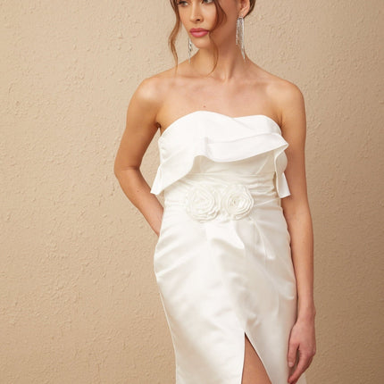 A long white satin dress with floral applique details and a maxi length silhouette