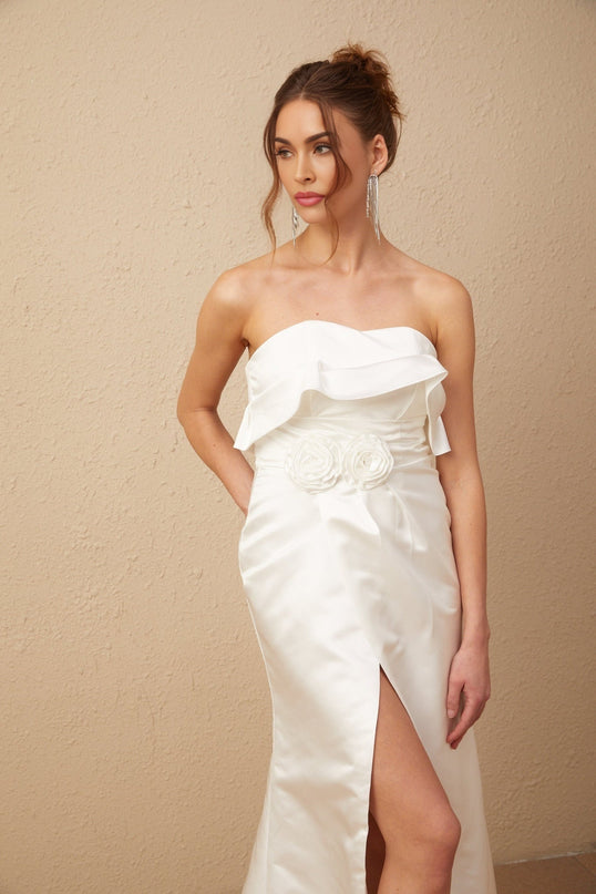 A long white satin dress with floral applique details and a maxi length silhouette