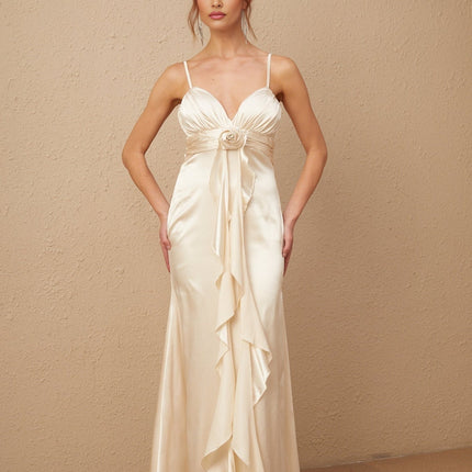 A long white satin maxi dress with a corset bodice featuring delicate floral appliques scattered across the fabric