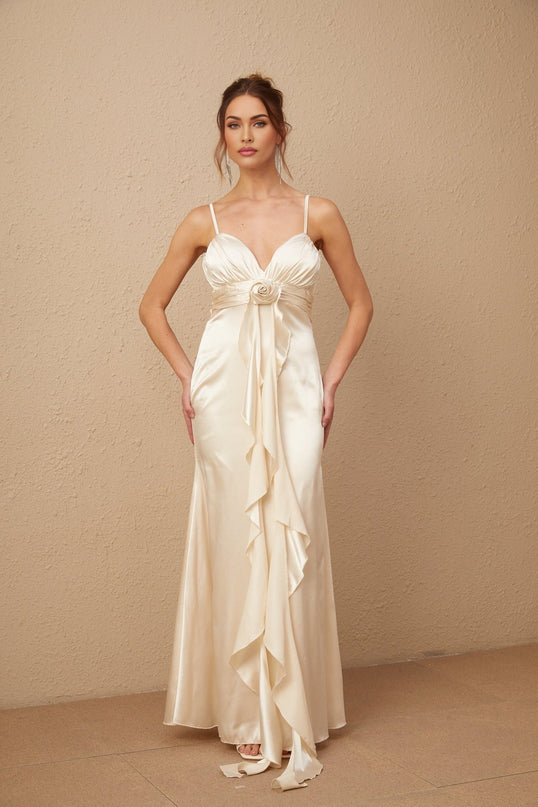 A long white satin maxi dress with a corset bodice featuring delicate floral appliques scattered across the fabric