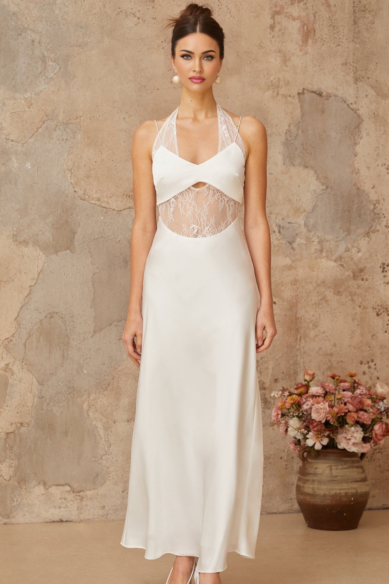 A long white satin maxi dress with lace panel details featuring a flowy silhouette and elegant design
