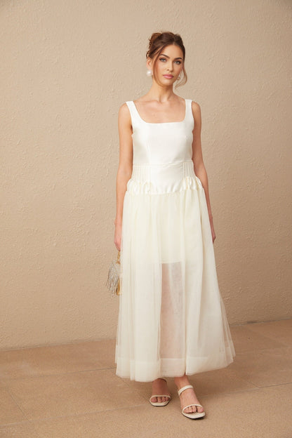 A long white satin maxi dress with tulle panels named Lucie featuring a flowing silhouette and elegant design