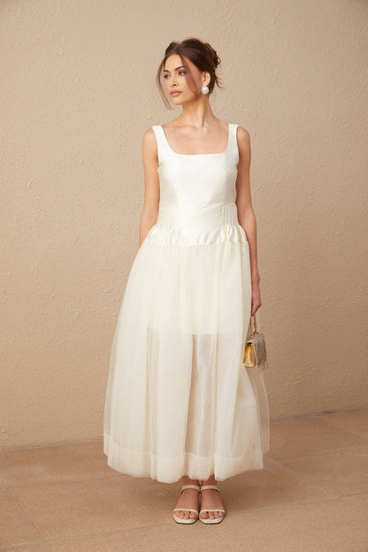 A long white satin maxi dress with tulle panels named Lucie featuring a flowy silhouette and elegant design