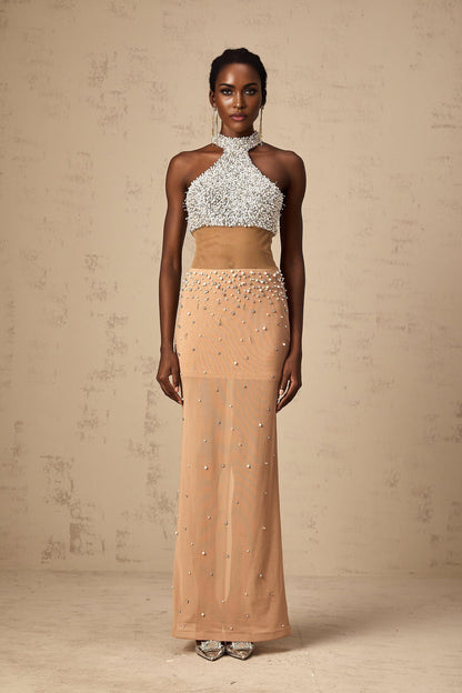 A long white semisheer maxi dress with faux pearl embellishments adorning the fabric named Rosa