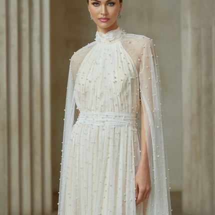 A long white tulle maxi dress with a cape design and embellishments featuring a flowy silhouette and elegant details