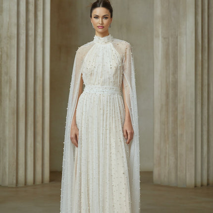 A long white tulle maxi dress with cape design and embellishments featuring a flowy silhouette and delicate detailing