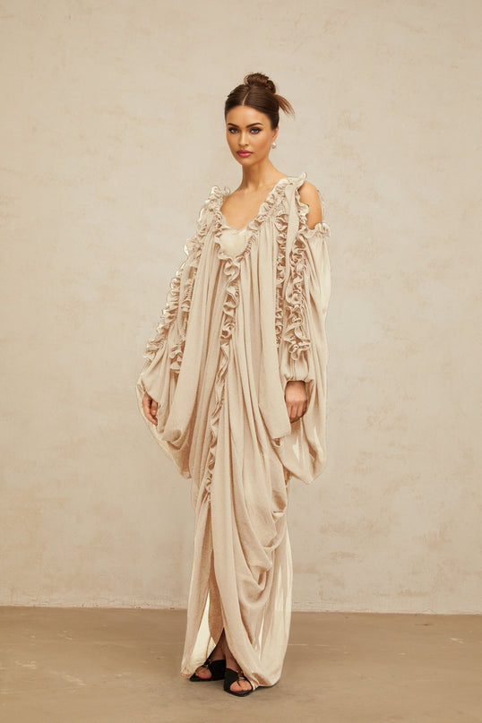 A long white tulle maxi dress with ruffled trim details and a flowy silhouette