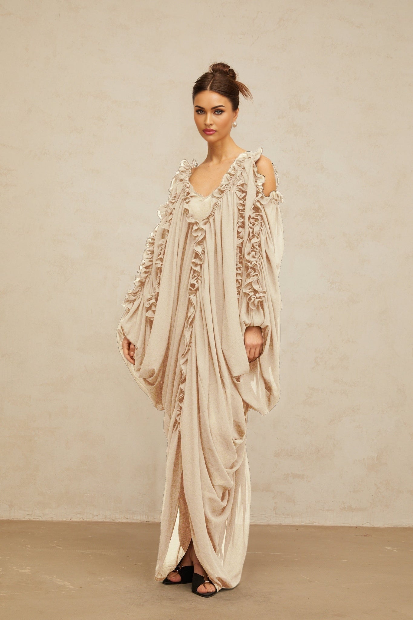 A long white tulle maxi dress with ruffled trim details and a flowy silhouette