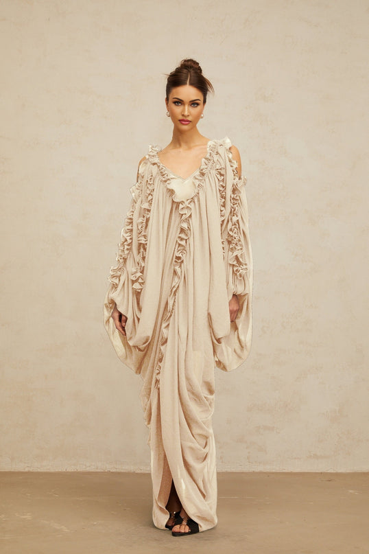 A long white tulle maxi dress with ruffled trim details on the bodice and skirt flowing ethereal design suitable for formal occasions