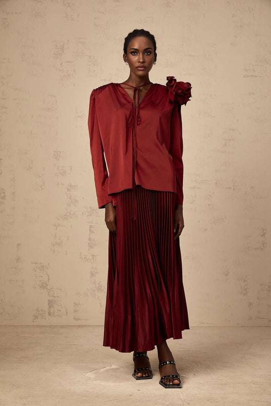 A matching set consisting of a blouse and skirt made from satin fabric The blouse features flower appliques The set is named Colette and has a coordinated elegant appearance