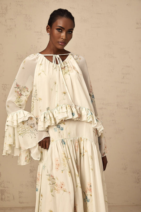 A matching set featuring a floral print blouse with ruffles and a coordinating dress in the same pattern