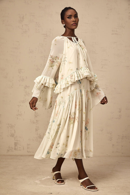 A matching set featuring a floral print blouse with ruffles and a coordinating dress in the same pattern