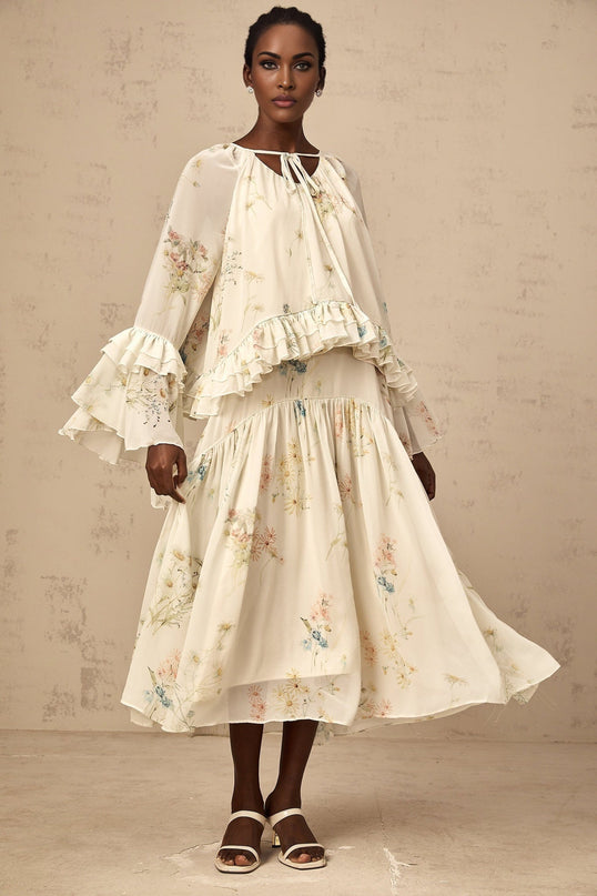 A matching set featuring a floral print blouse with ruffles and a coordinating dress in the same pattern