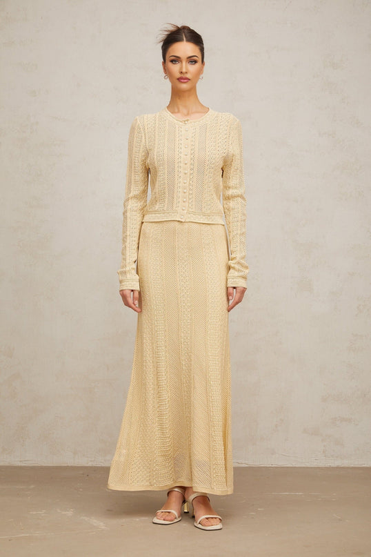 A matching set featuring a pointelleknit cardigan and skirt in a light color named Tiphaine The cardigan has a delicate open weave pattern and the skirt is knee length Both pieces have a feminine and intricate design