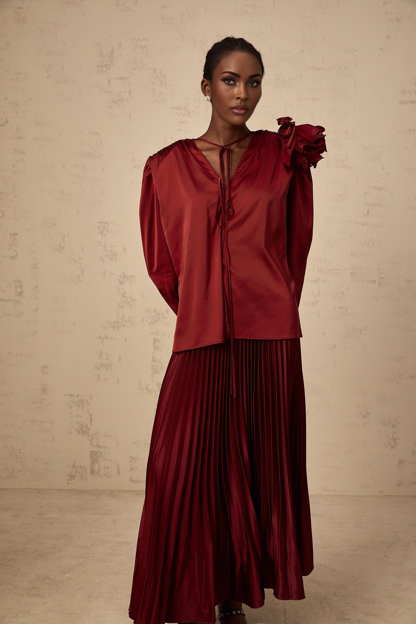 A matching set featuring a satin blouse and skirt with floral applique details named Colette The blouse and skirt are coordinated and decorated with delicate flower embellishments